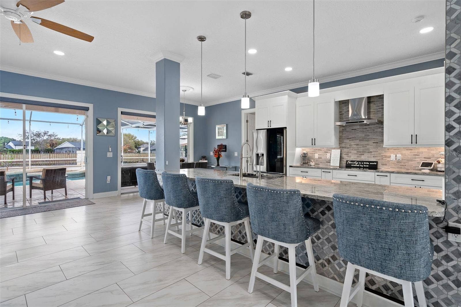 9057 BALMORAL MEWS SQUARE, Windermere, FL 34786 Kitchen has custom backsplash and a stone accent wall. This Chefs kitchen has been completely remodeled with new white shaker cabinets, a large breakfast bar, built in oven and microwave and granite countertops.