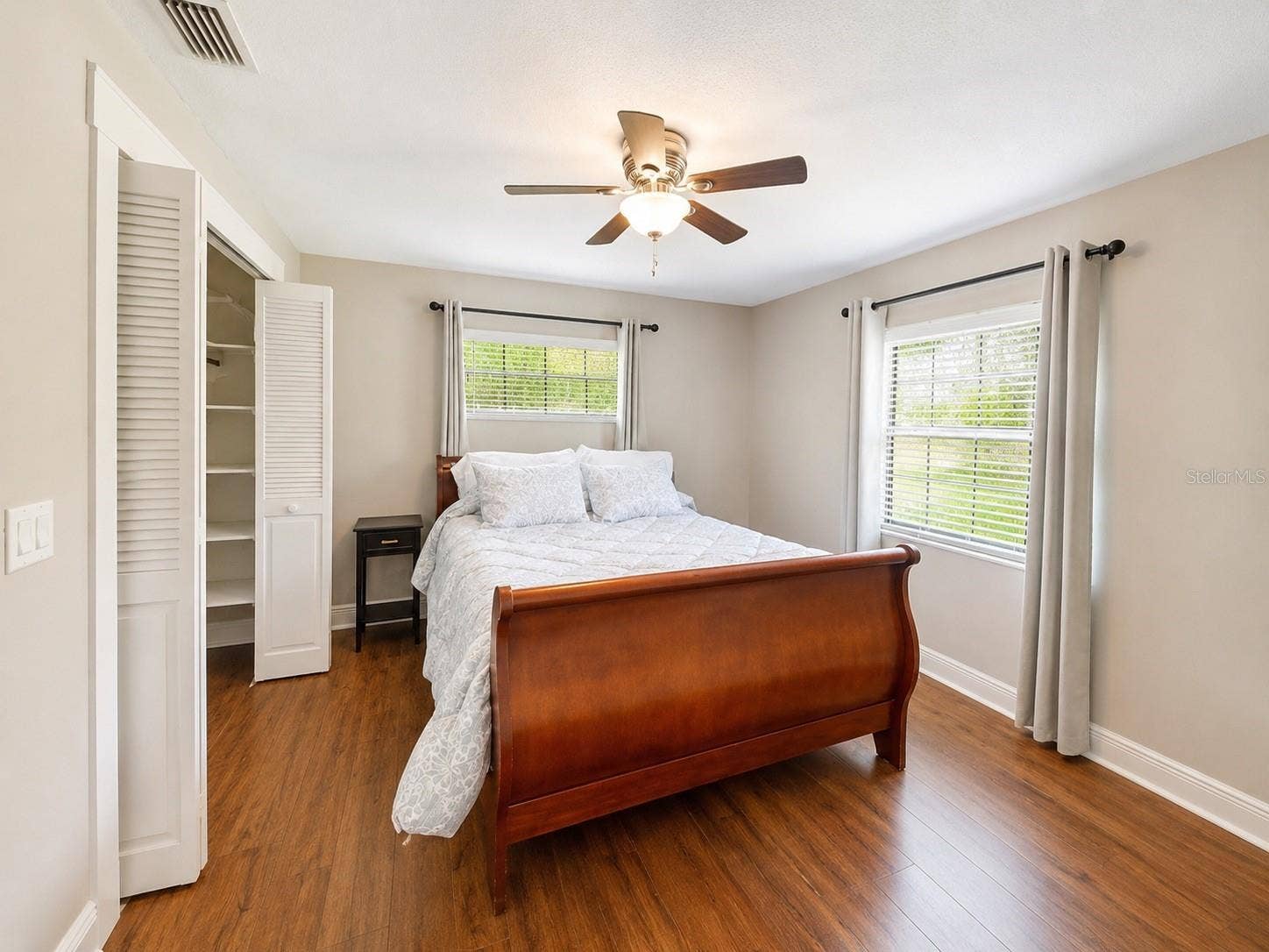 14140 COUNTRY ESTATE DRIVE, Winter Garden, FL 34787 Bright secondary bedroom with warm wood-like floors, great natural light, and a spacious closet for extra storage.