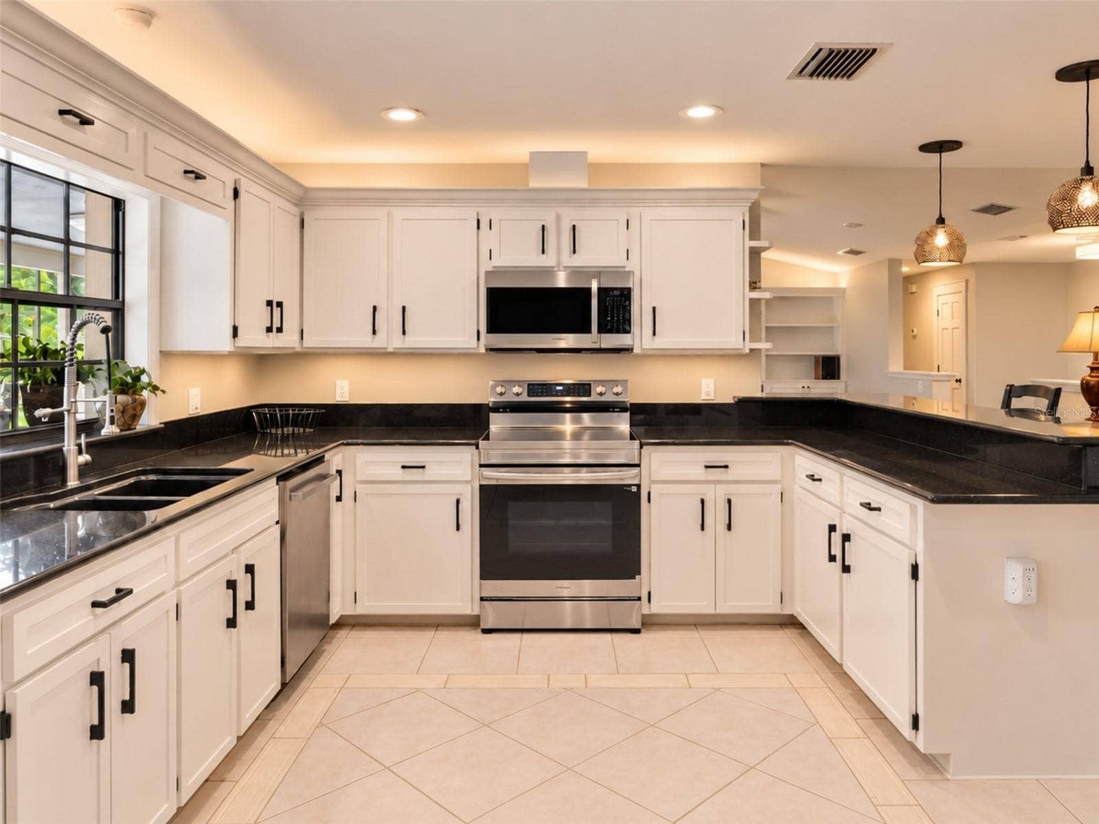 14140 COUNTRY ESTATE DRIVE, Winter Garden, FL 34787 Bright kitchen with abundant cabinetry, granite countertops, stainless steel appliances, and a brand new rang with air fry feature- plus under-and above- cabinet lighting. Pass-through window to the pool with serving counter makes outdoor entertaining effortless.