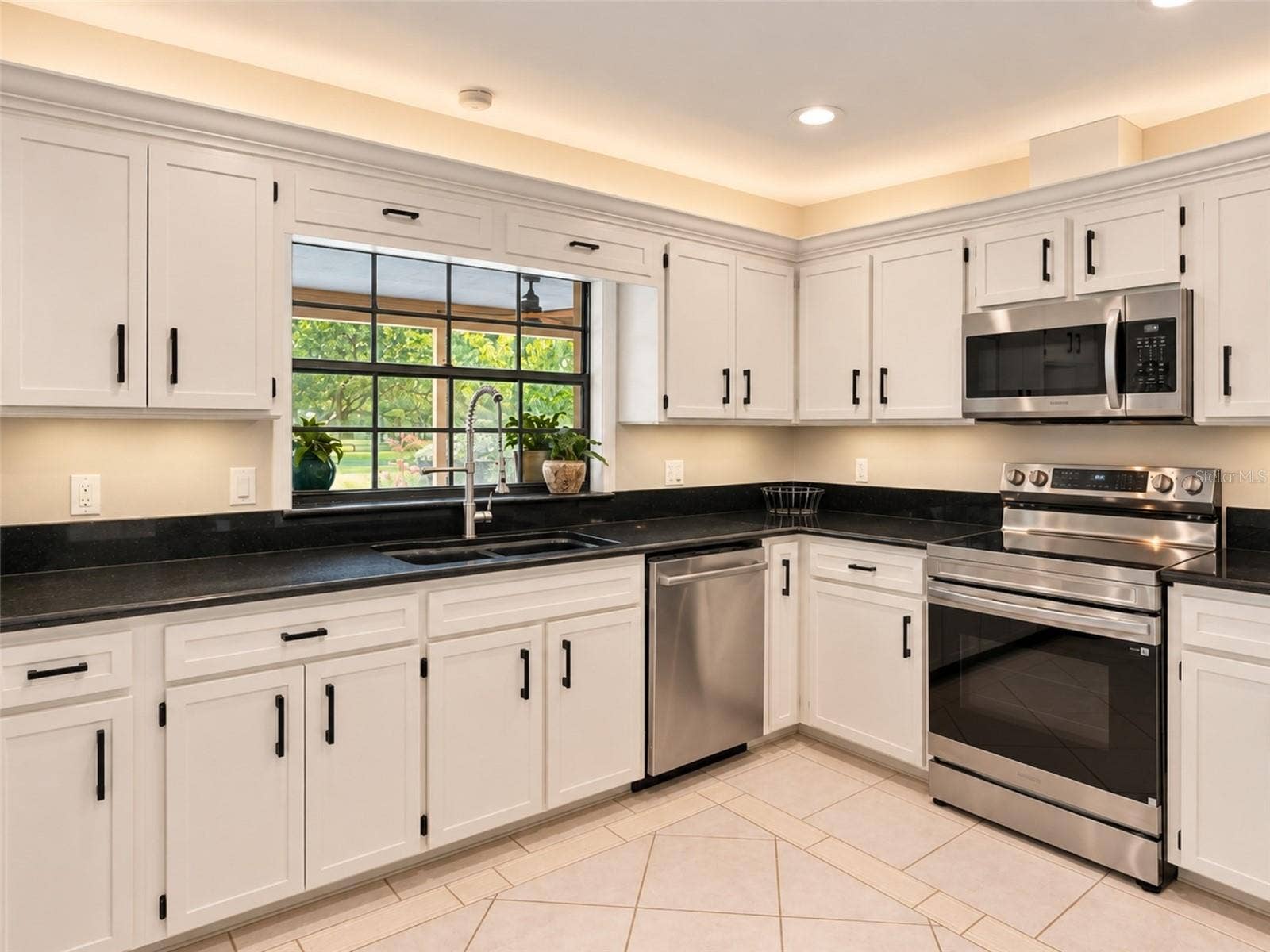 14140 COUNTRY ESTATE DRIVE, Winter Garden, FL 34787 Bright kitchen with abundant cabinetry, granite countertops, stainless steel appliances, and a brand new rang with air fry feature- plus under-and above- cabinet lighting. Pass-through window to the pool with serving counter makes outdoor entertaining effortless.