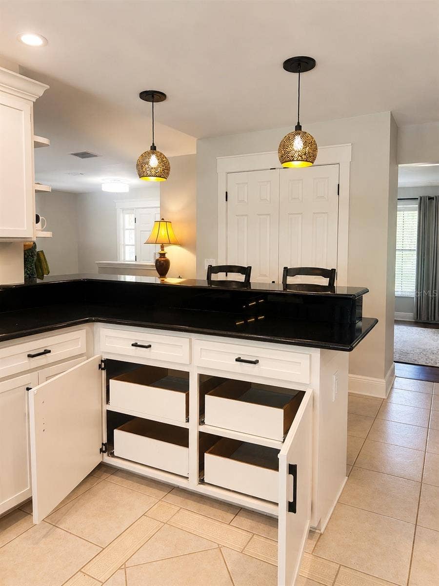 14140 COUNTRY ESTATE DRIVE, Winter Garden, FL 34787 Chic kitchen details shine with warm pendant lighting, a convenient breakfast bar, and pull-out lower cabinets that make storage both stylish and functional.
