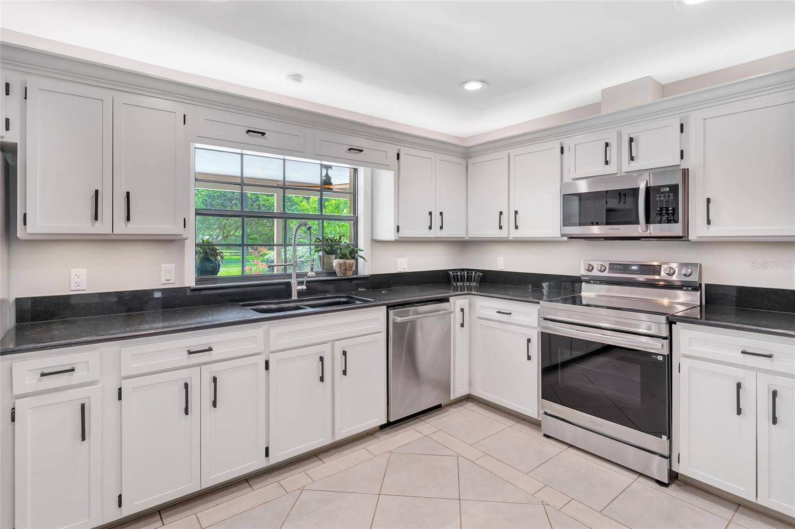 14140 COUNTRY ESTATE DRIVE, Winter Garden, FL 34787 Bright kitchen with abundant cabinetry, granite countertops, stainless steel appliances, and a brand new rang with air fry feature- plus under-and above- cabinet lighting. Pass-through window to the pool with serving counter makes outdoor entertaining effortless.