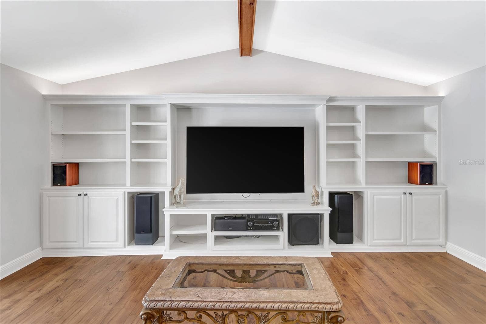 14140 COUNTRY ESTATE DRIVE, Winter Garden, FL 34787 Custom built-in entertainment wall with extensive shelving, cabinetry, and a seamless media setup- designed for both style and function.