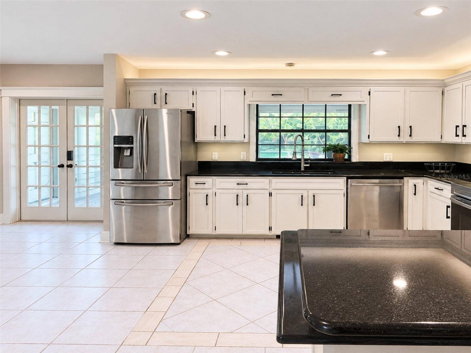 14140 COUNTRY ESTATE DRIVE, Winter Garden, FL 34787 Bright kitchen with abundant cabinetry, granite countertops, stainless steel appliances, and a brand new rang with air fry feature- plus under-and above- cabinet lighting. Pass-through window to the pool with serving counter makes outdoor entertaining effortless.