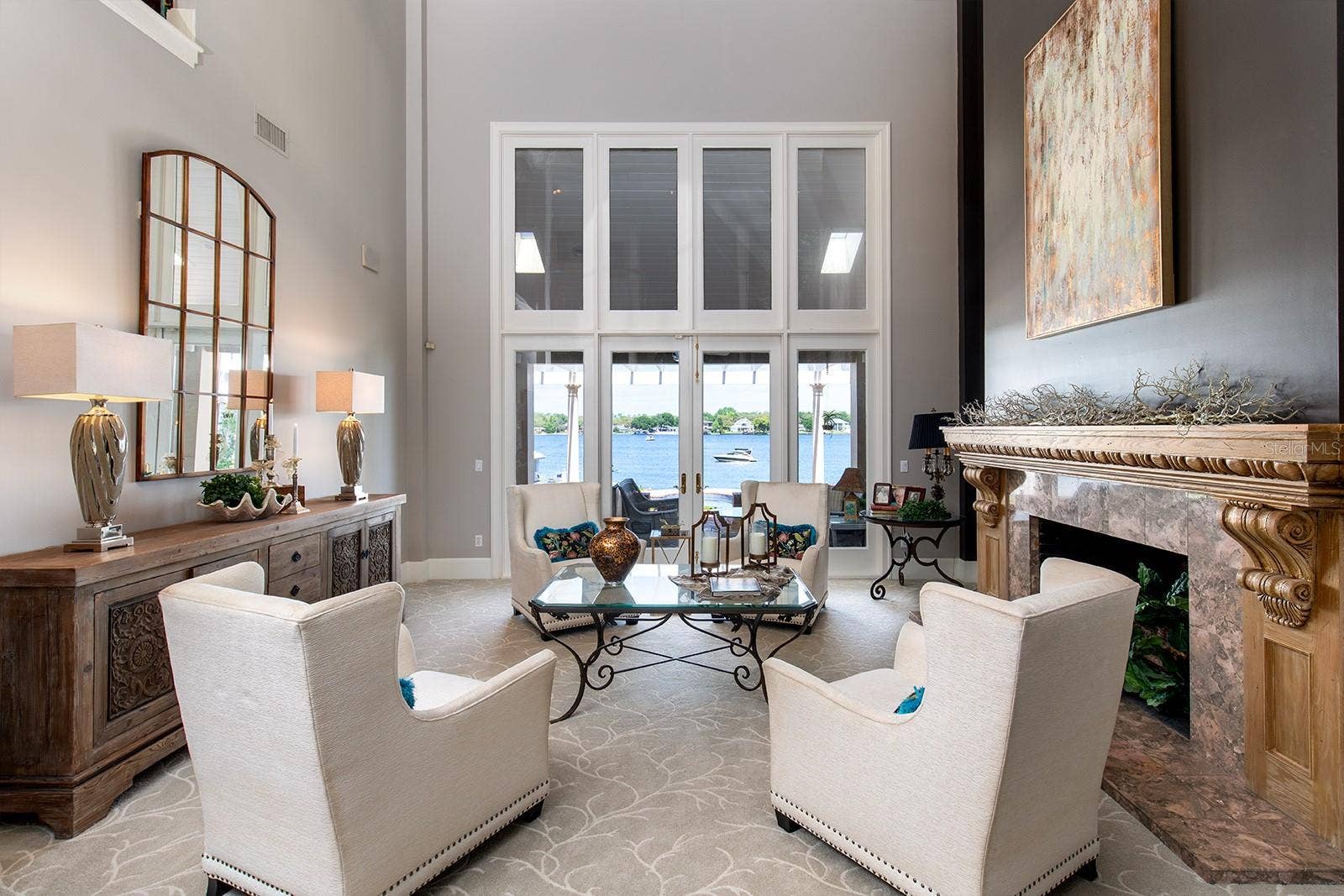 1351 N CLASSIC COURT, Longwood, FL 32779 Formal living room is stately and impressive with its marble fireplace and hand carved mantel and panoramic water views that welcome the outside in.