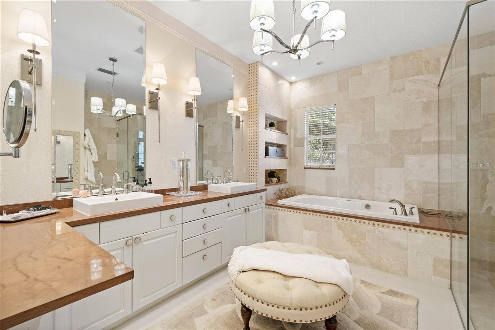 11051 HAWKSHEAD COURT, Windermere, FL 34786 Primary bath with luxury lighting, travertine accent walls. Separate whirlpool bath and large walk in shower. Stone counters.