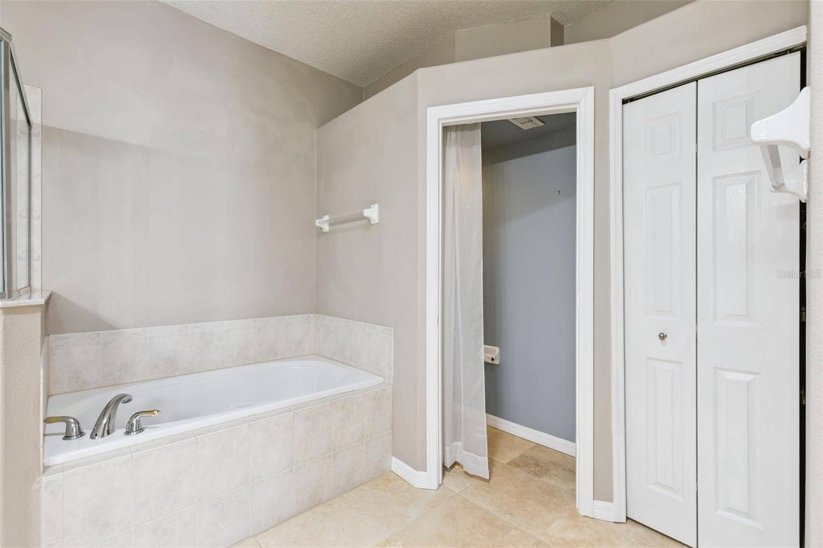 237 STRATHMORE CIRCLE, Kissimmee, FL 34744 Garden tub and linen closet in primary bathroom.