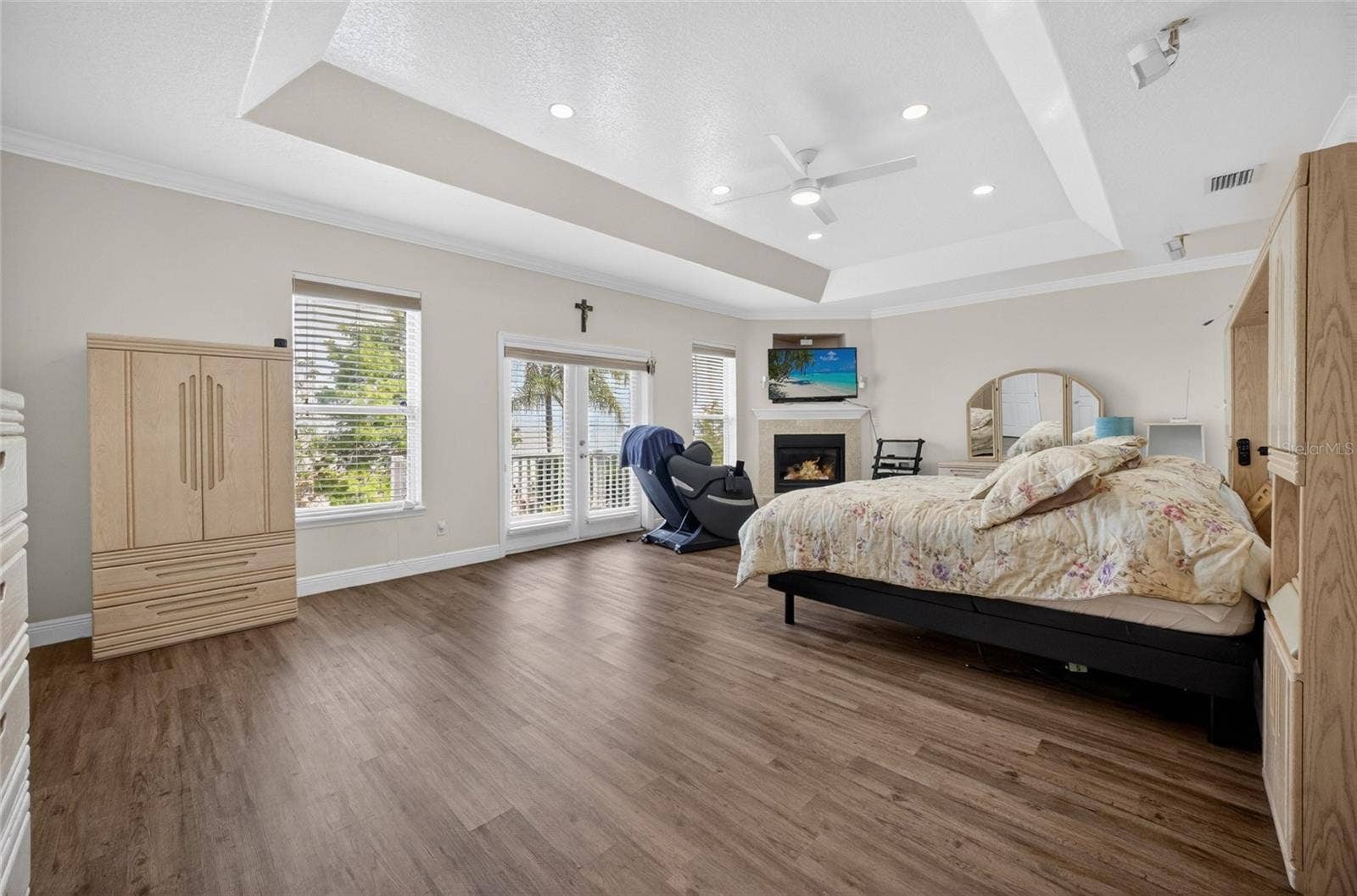 279 ZACHARY WADE STREET, Winter Garden, FL 34787 Primary bedroom upstairs with tray ceiling, corner fireplace and ensuite bath. French doors lead to the balcony overlooking the lake and pool area