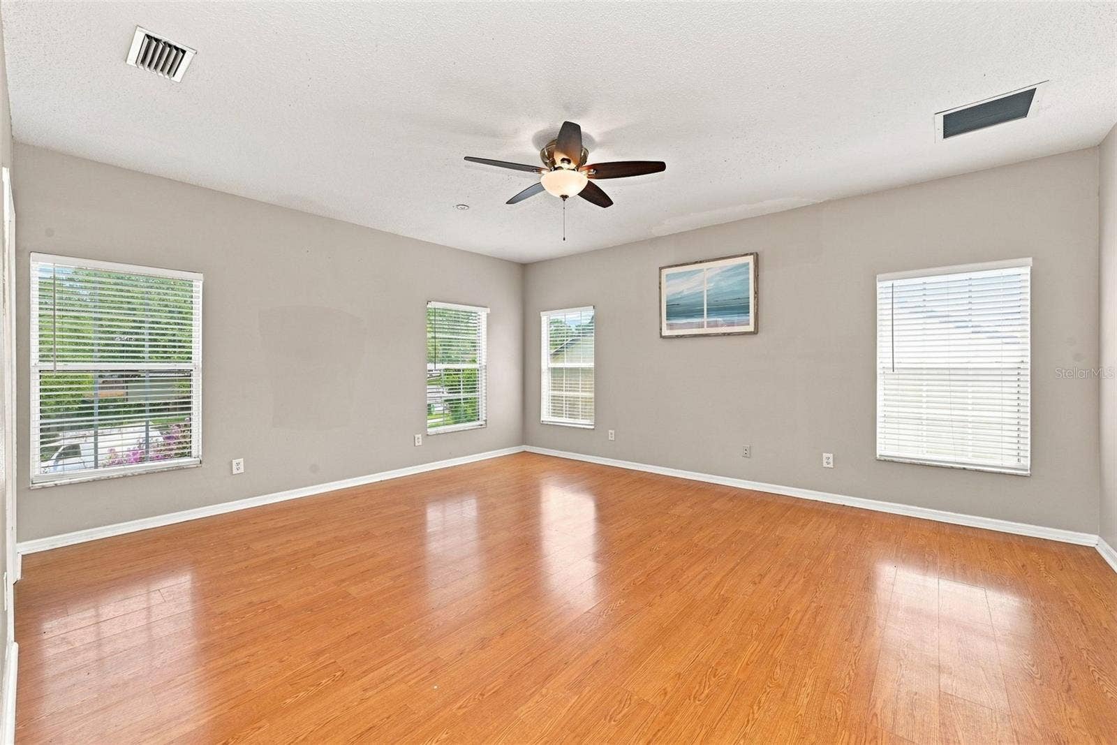 1349 VALLEY PINE CIRCLE, Apopka, FL 32712 Expansive Primary Suite offers generous space, abundant natural light, and multiple windows overlooking the surrounding property.