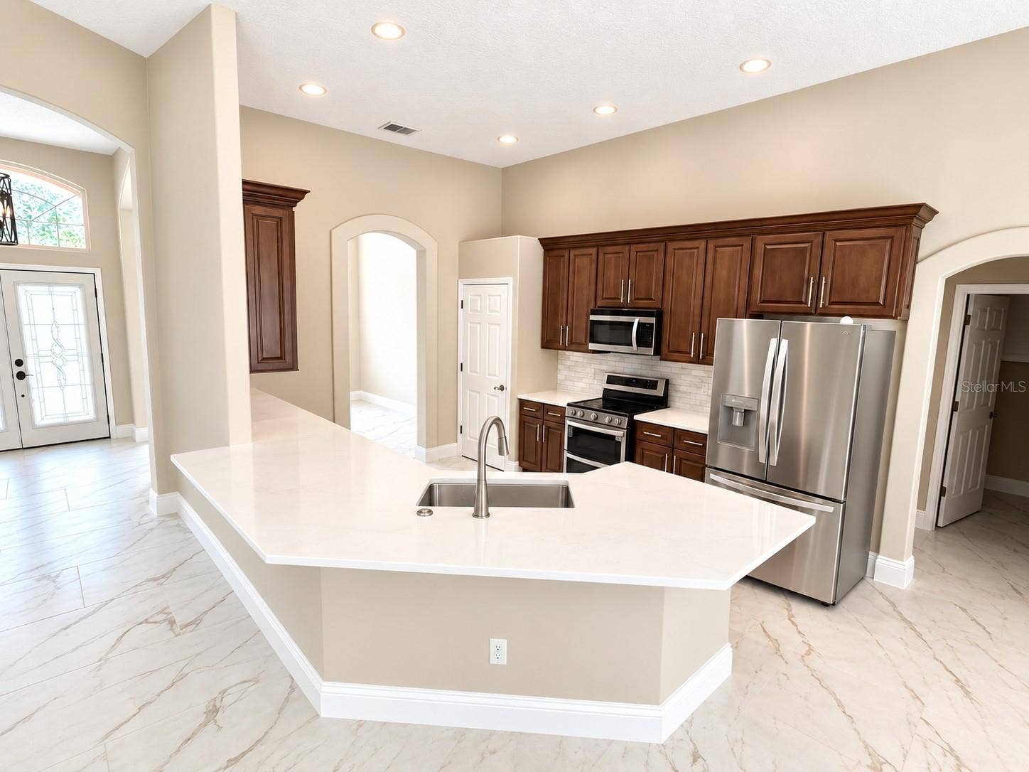 The kitchen now has a one level countertop/breakfast bar and the new backsplash to give it a light and bright look.