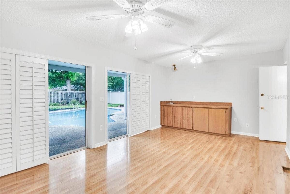 715 S RANGER BOULEVARD, Winter Park, FL 32792 Living area #3 to pool deck with plantation shuttered sliding doors.