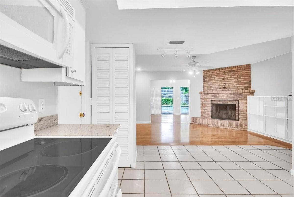 715 S RANGER BOULEVARD, Winter Park, FL 32792 Kitchen to living area with beautiful brick fireplace.