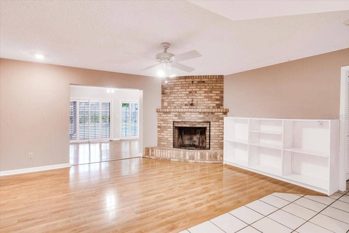 715 S RANGER BOULEVARD, Winter Park, FL 32792 Living area to private pool area entry features brick fireplace and hardwood flooring.