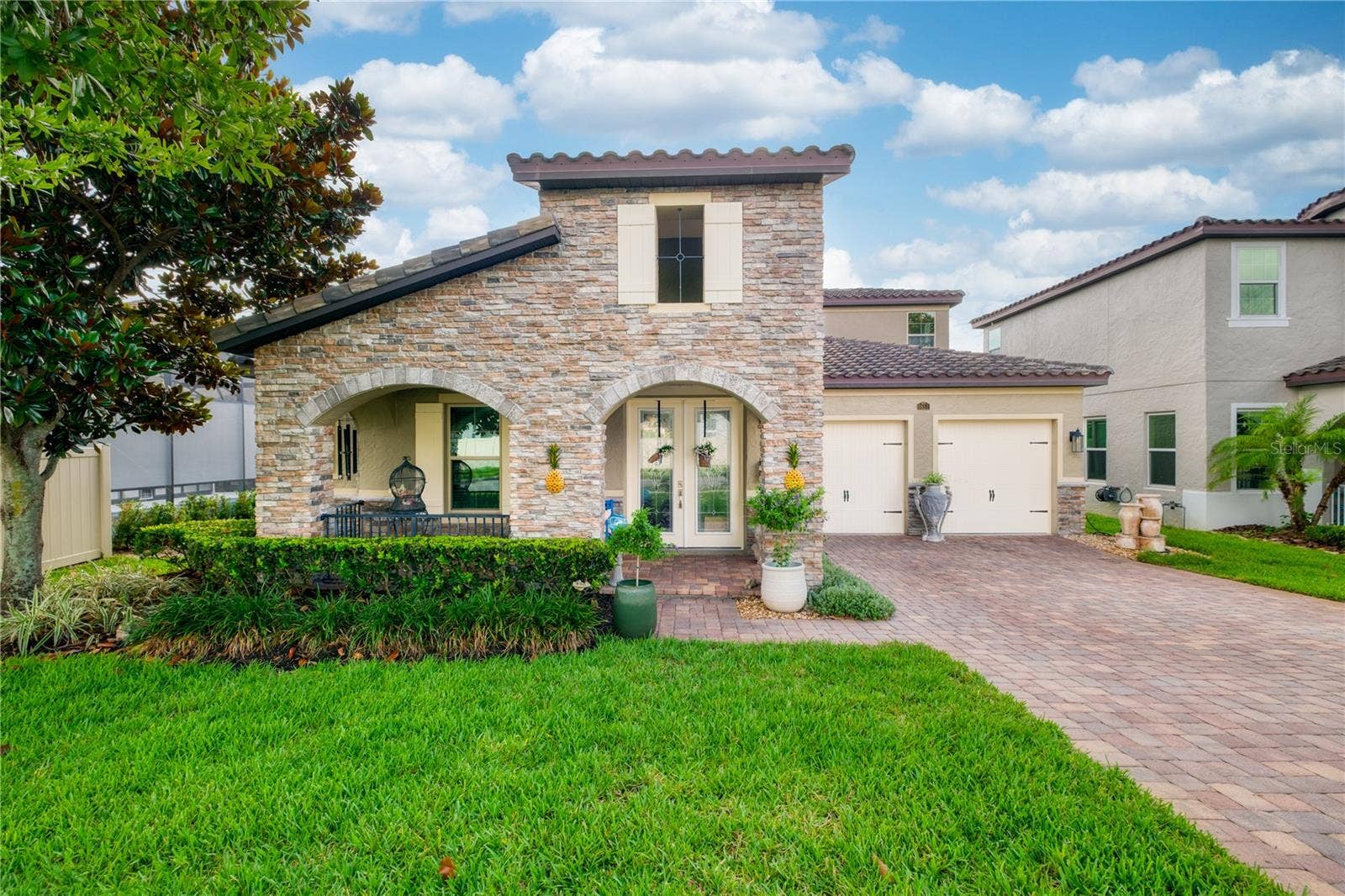 1651 AMSEL FALLS PARK TERRACE, Winter Garden, FL 34787 North-facing front elevation featuring a two-car garage and a welcoming front porch.