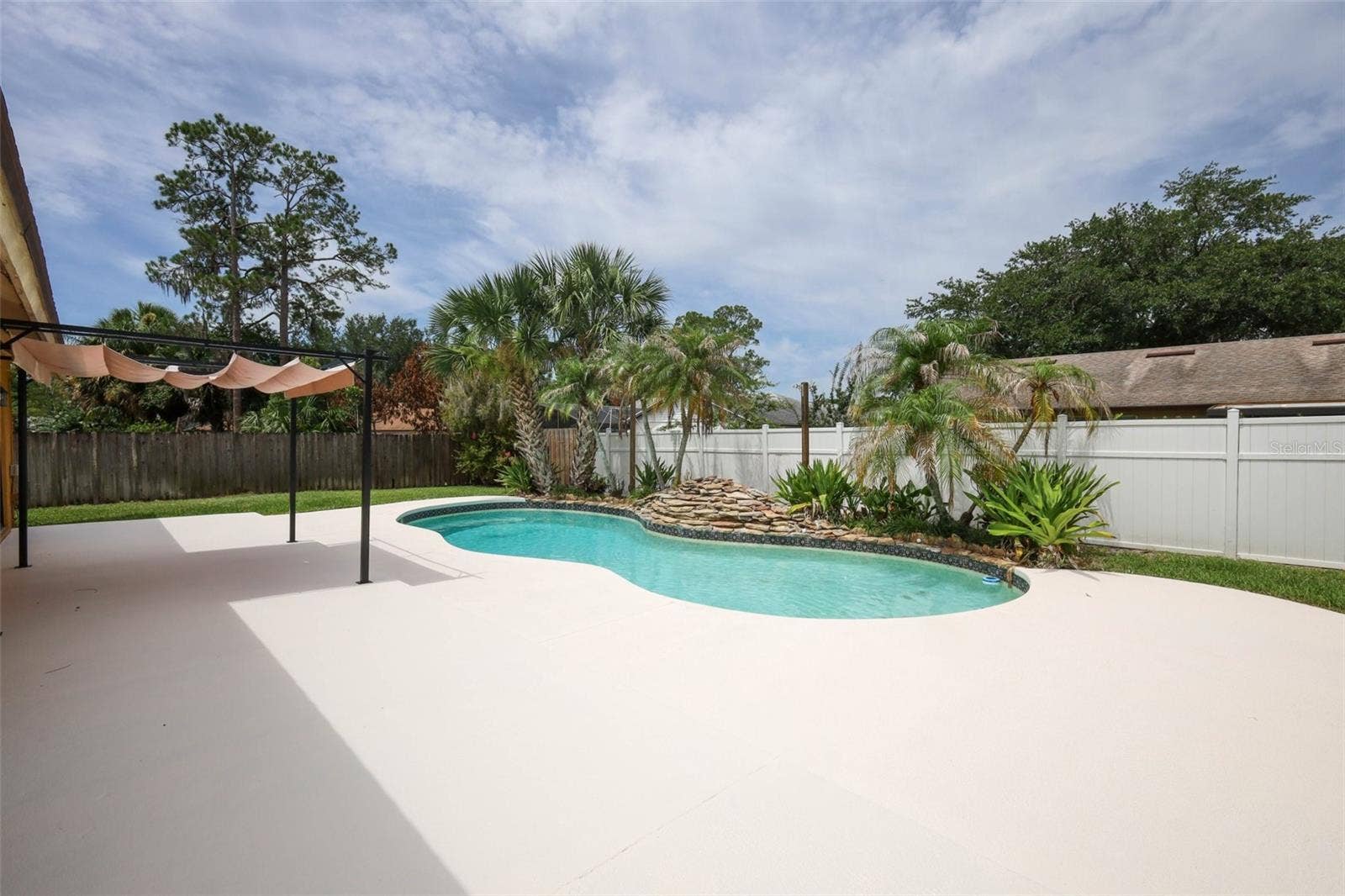 Rear yard with an open-air sparkling pool with space for the kids and pets to play.