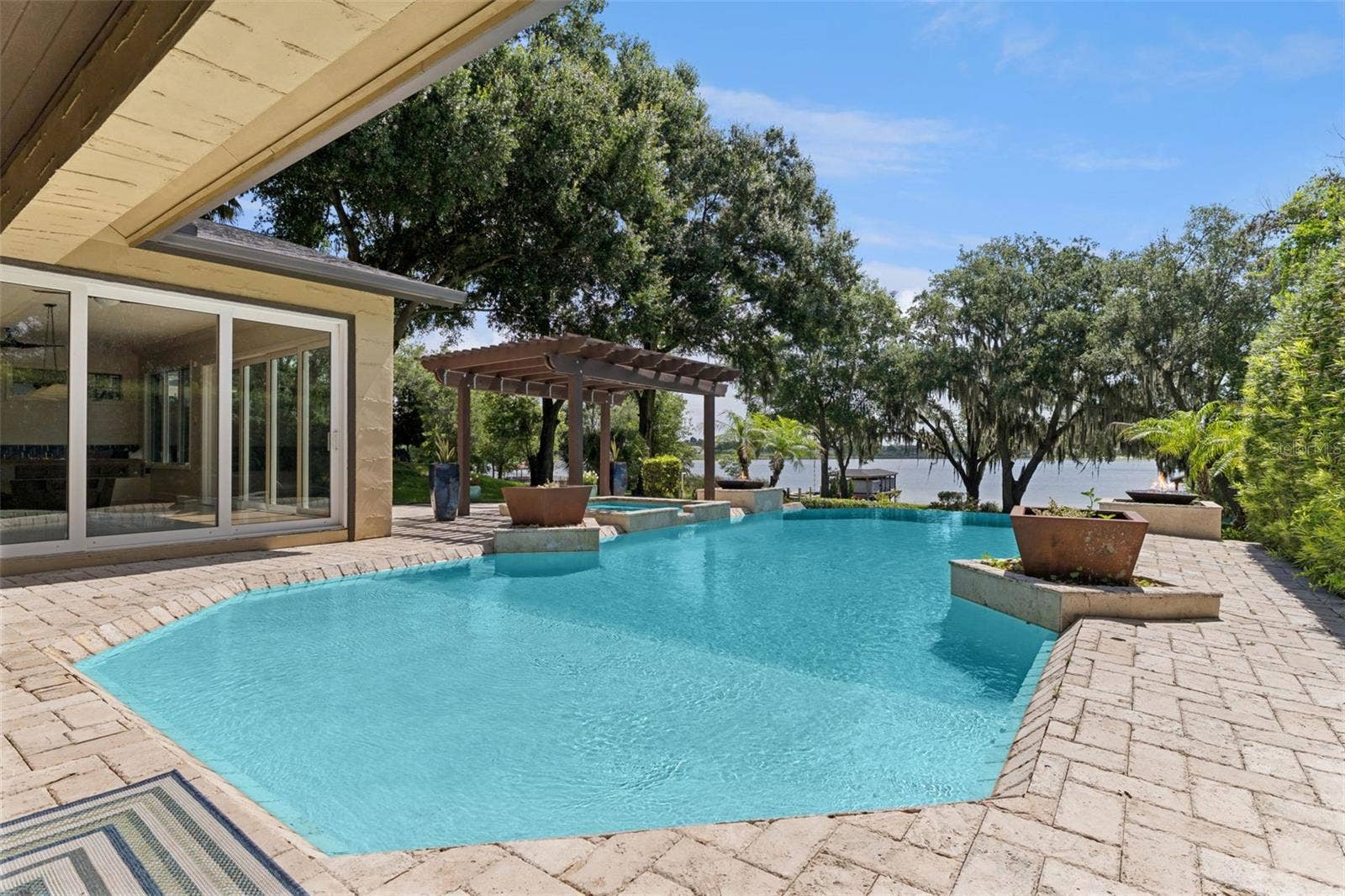 1629 HEMPEL AVENUE, Windermere, FL 34786 Infinity Pool and Spa. Decorative planters and two natural gas fed fire pit features complete the luxury pool experience