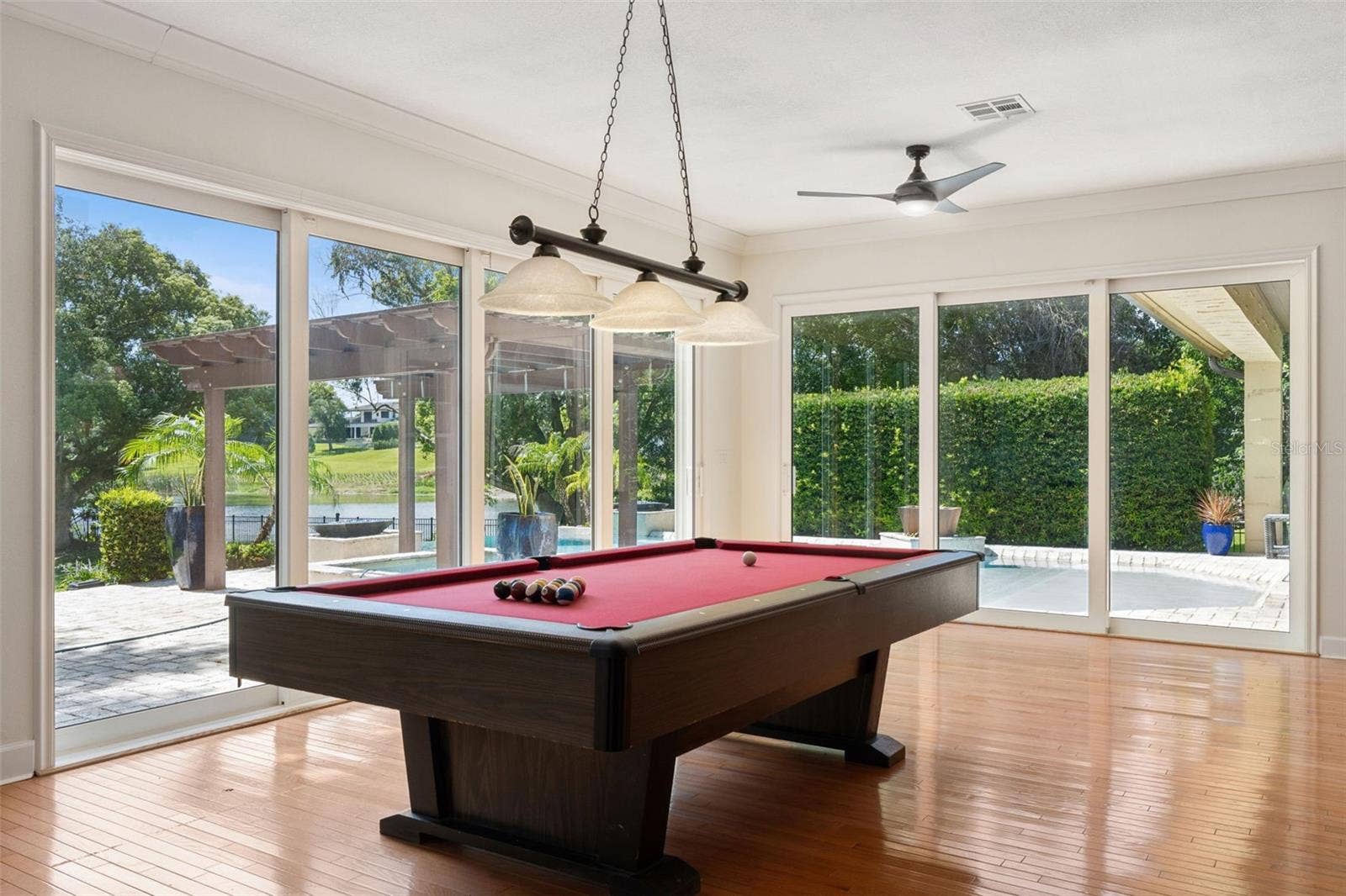 1629 HEMPEL AVENUE, Windermere, FL 34786 Game Room with view of the Pool and Lake. Beautiful natural wood floor. Sliding Energy effcient doors for the open air experience