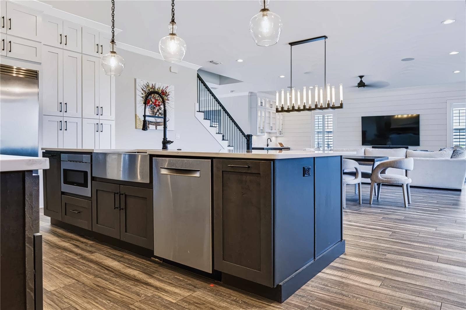 907 CELADON STREET, Winter Garden, FL 34787 OVERSIZED CENTER ISLANDThe oversized center island incorporates an apron-front sink, dishwasher and under-counter microwave, with generous prep space and an open connection to the dining and living areas beyond.