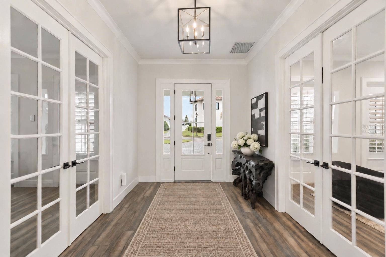 907 CELADON STREET, Winter Garden, FL 34787 Virtually staged, runner and floral added. Looking toward the front entry, the foyer is framed by double French doors leading to a dedicated executive office on one side and a flexible en suite guest or au pair room on the other