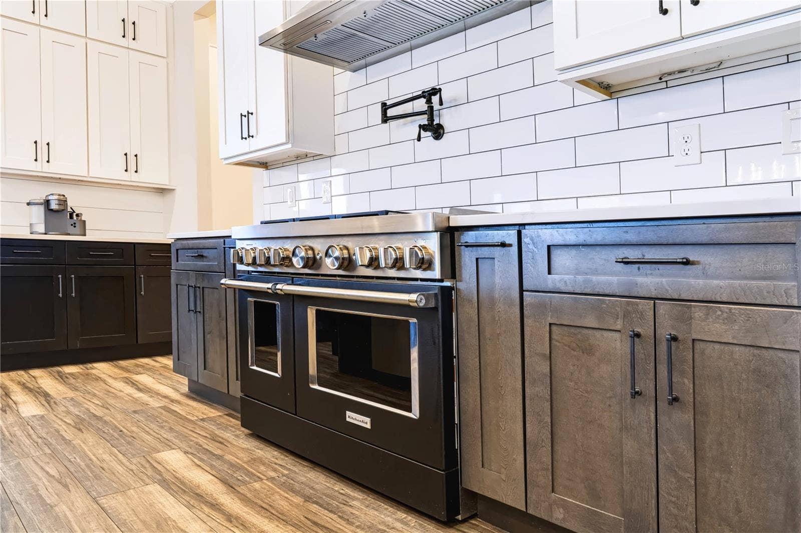 907 CELADON STREET, Winter Garden, FL 34787 PROFESSIONAL-STYLE COOKING | KITCHEN AID OVENSA substantial range, vent hood and pot filler create a dedicated cooking zone surrounded by generous counter space and cabinetry.