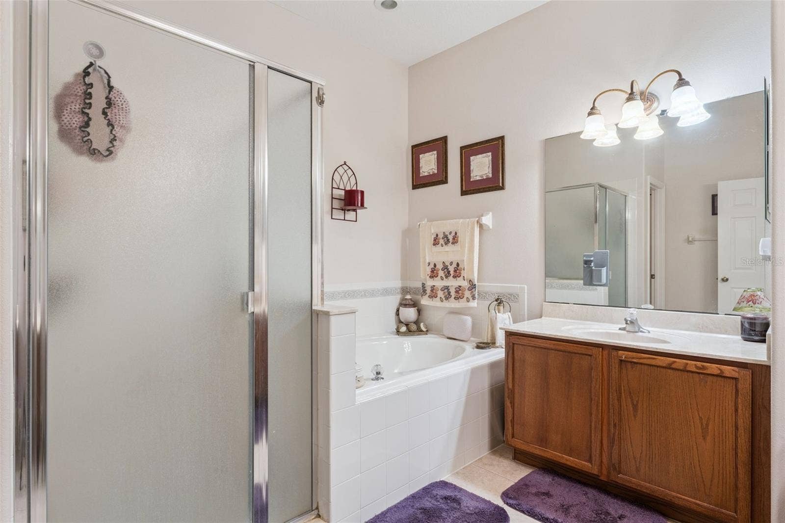 9955 MEDALLION BLUFF LANE, Orlando, FL 32829 Primary bathroom features a walk in shower & spa like tub