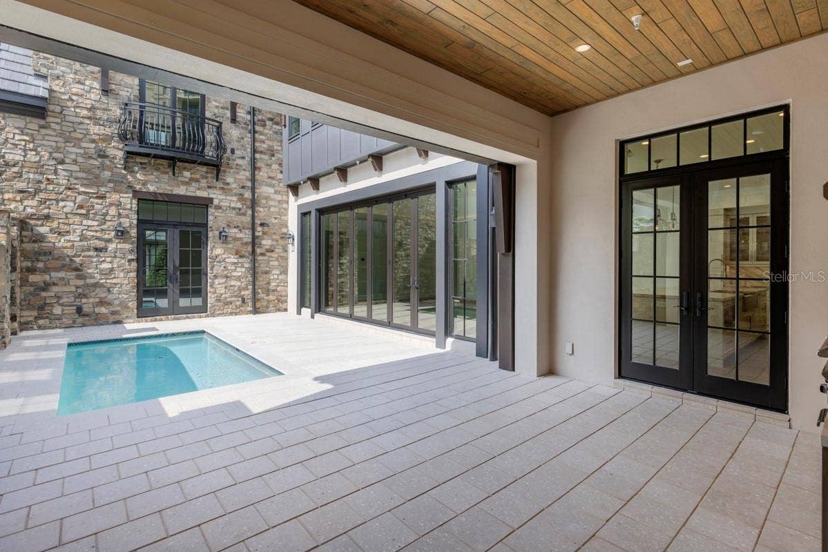 10335 WINTER SPARKLE CIRCLE, Golden Oak, FL 32836 Outdoor living area with summer kitchen and heated lounging pool