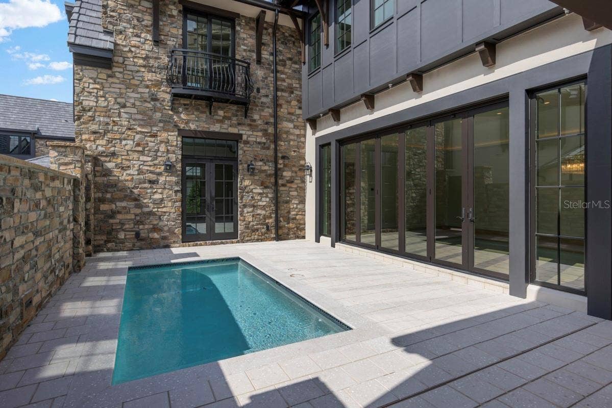 10335 WINTER SPARKLE CIRCLE, Golden Oak, FL 32836 Outdoor living area with summer kitchen and heated lounging pool