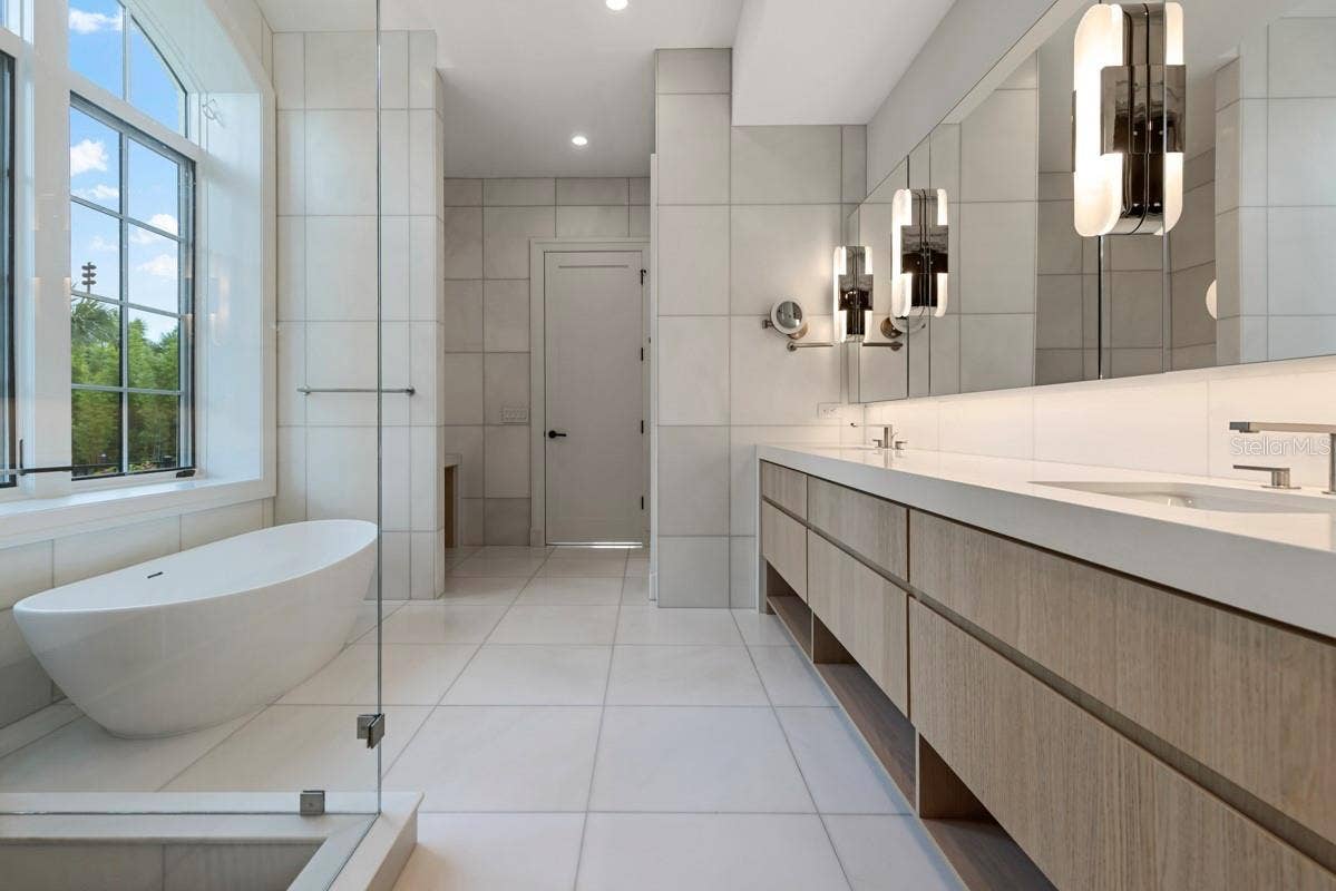 10335 WINTER SPARKLE CIRCLE, Golden Oak, FL 32836 Indulgent primary bath features a freestanding tub, along withcustom vanities, marble floors, walls and shower with full-length shower bench and niche