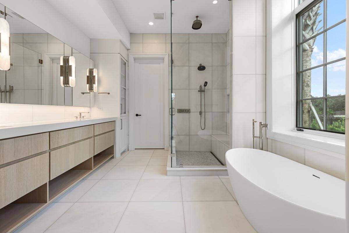 10335 WINTER SPARKLE CIRCLE, Golden Oak, FL 32836 Indulgent primary bath features a freestanding tub, along withcustom vanities, marble floors, walls and shower with full-length shower bench and niche