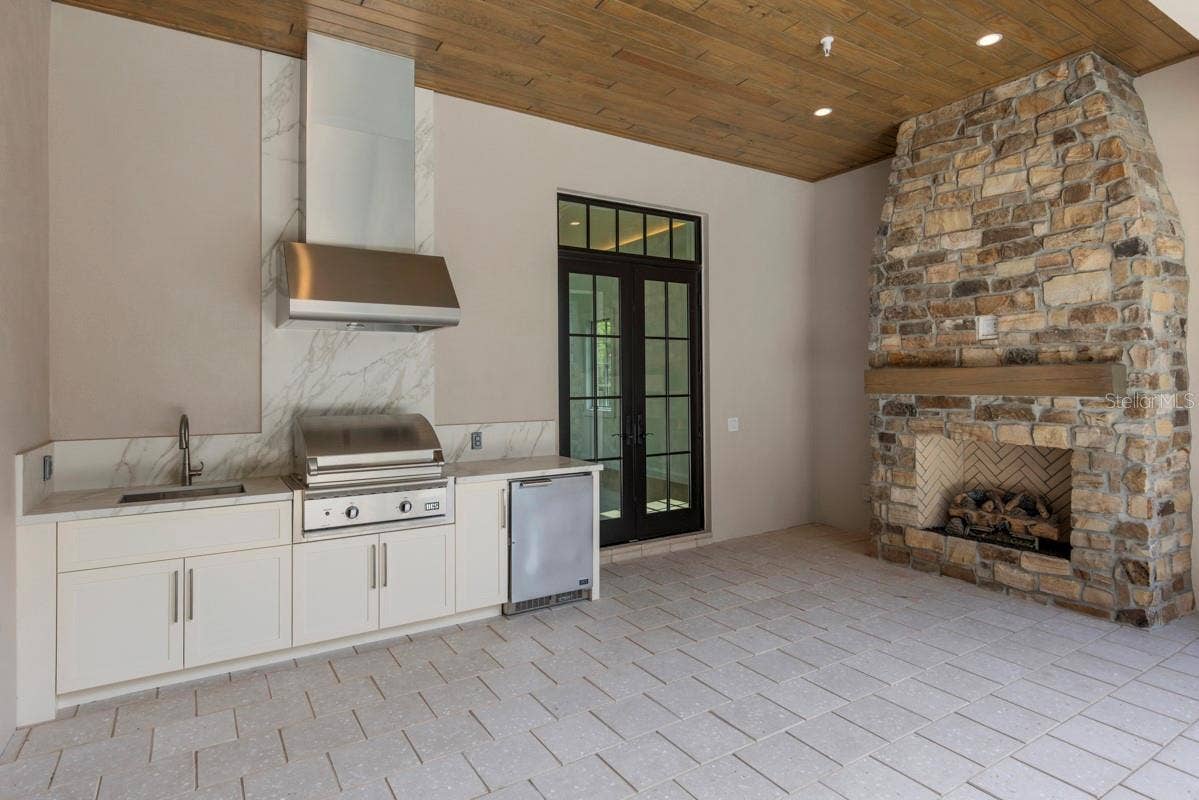 10335 WINTER SPARKLE CIRCLE, Golden Oak, FL 32836 Outdoor living area with summer kitchen and heated lounging pool
