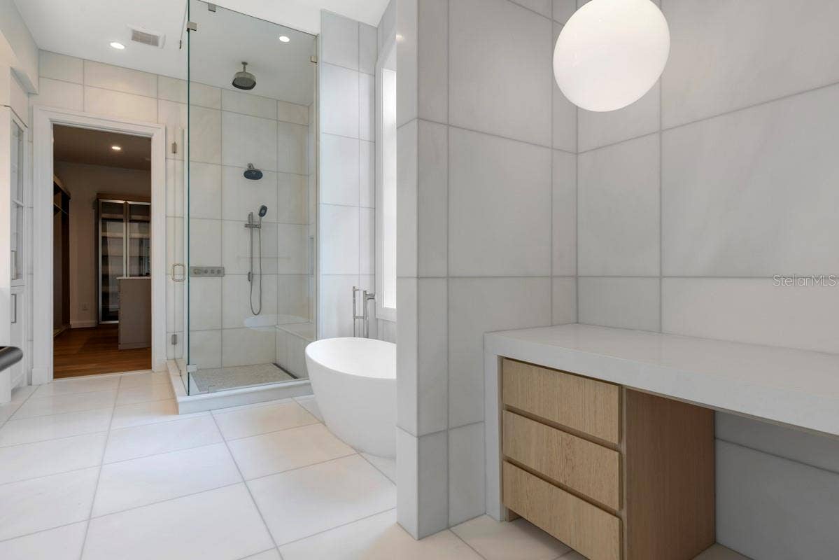 10335 WINTER SPARKLE CIRCLE, Golden Oak, FL 32836 Indulgent primary bath features a freestanding tub, along withcustom vanities, marble floors, walls and shower with full-length shower bench and niche