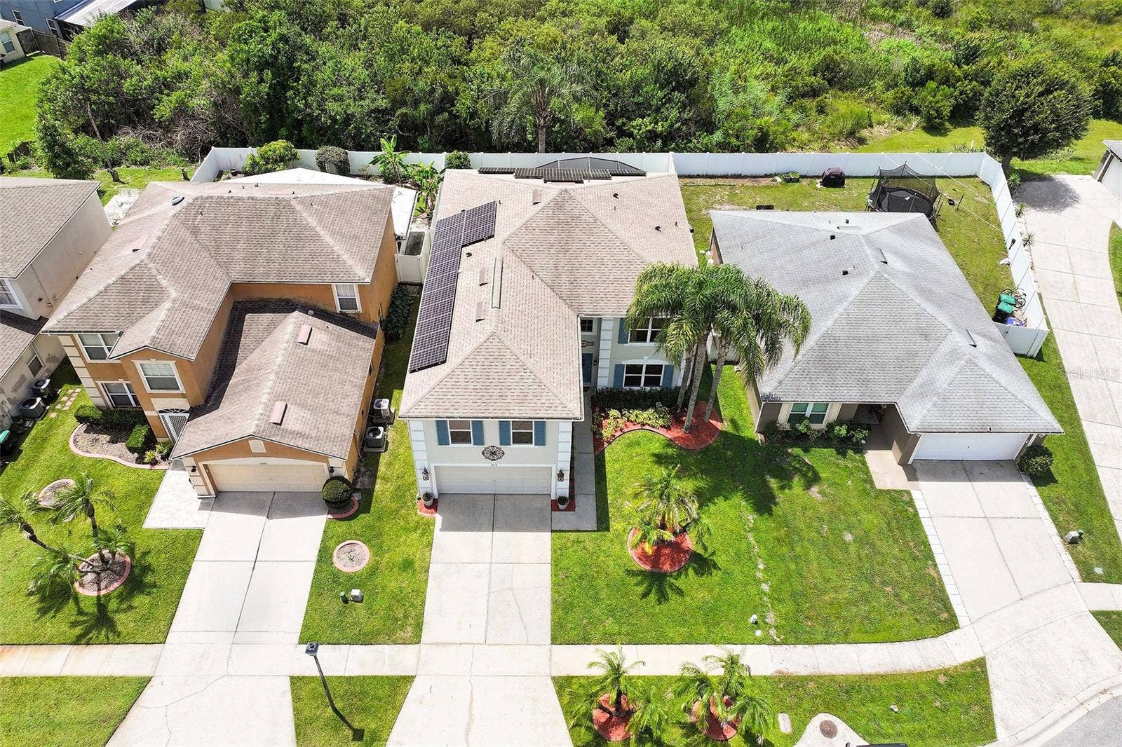 1424 AGUACATE COURT, Orlando, FL 32837 Aerial view highlighting the home's solar panels, fencing and the conservation at the back