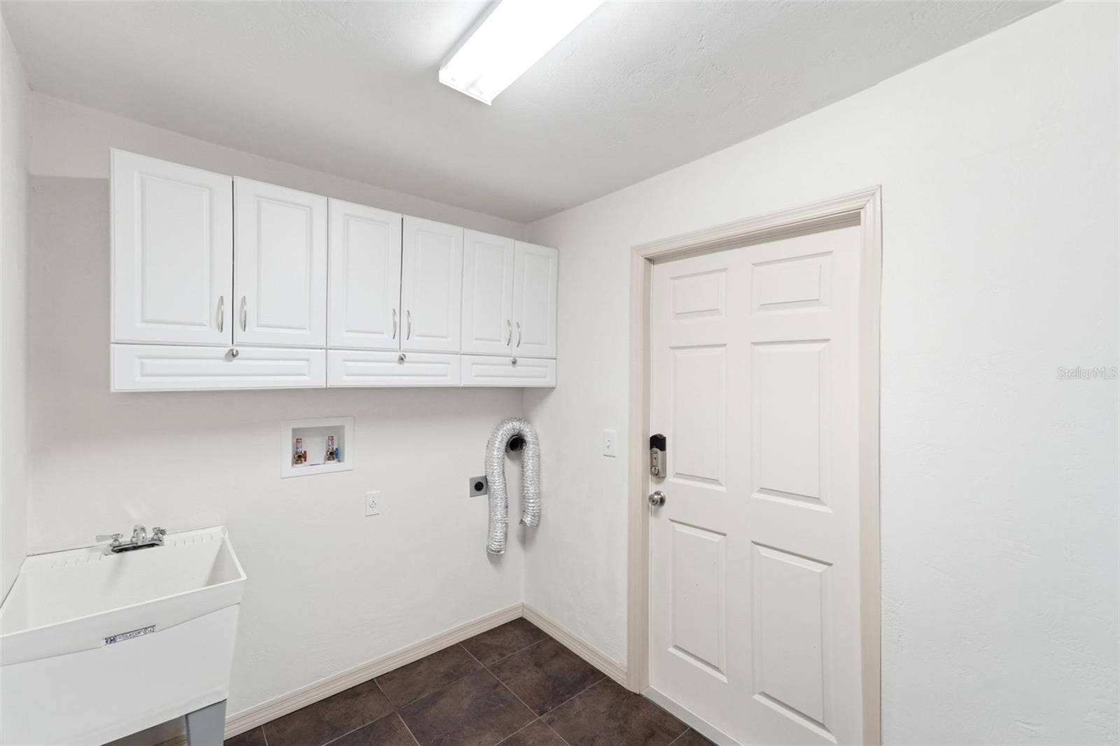 59 CRESTWOOD CIRCLE, Ormond Beach, FL 32174 Functional laundry room with additional cabinetry for extra storage.