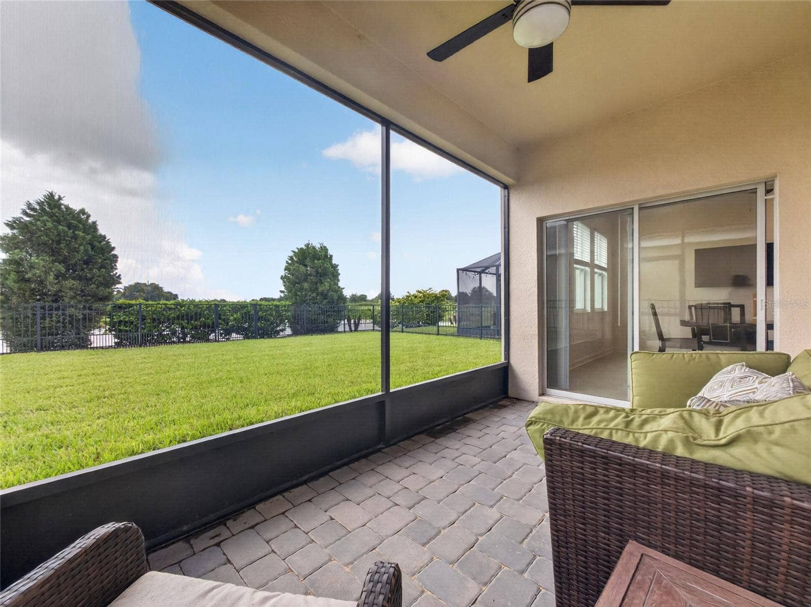 8813 BETH PAGE LANE, Davenport, FL 33896 Screened-in pavered lanai overlooking a fully fenced backyard with beautiful golf course viewsthe perfect spot to relax and enjoy Florida living.