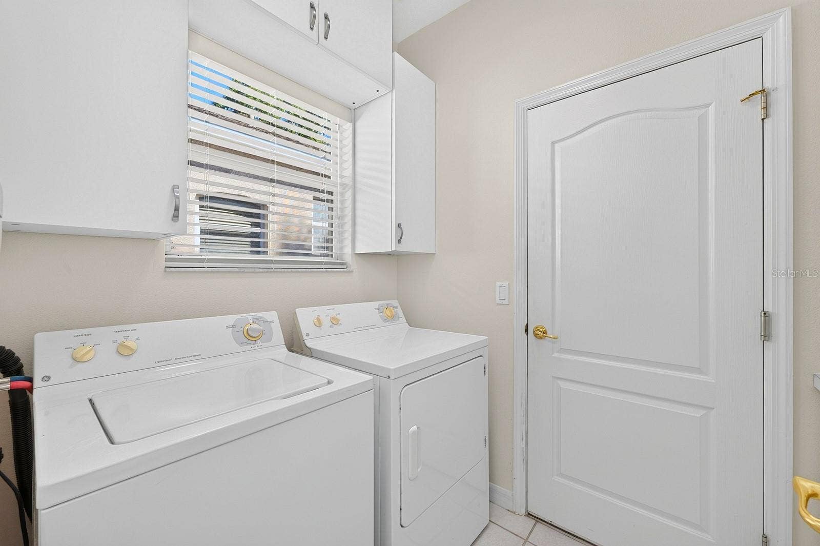 A Laundry Room just off the Kitchen, is complete with washer, dryer, storage cabinets and a folding table.