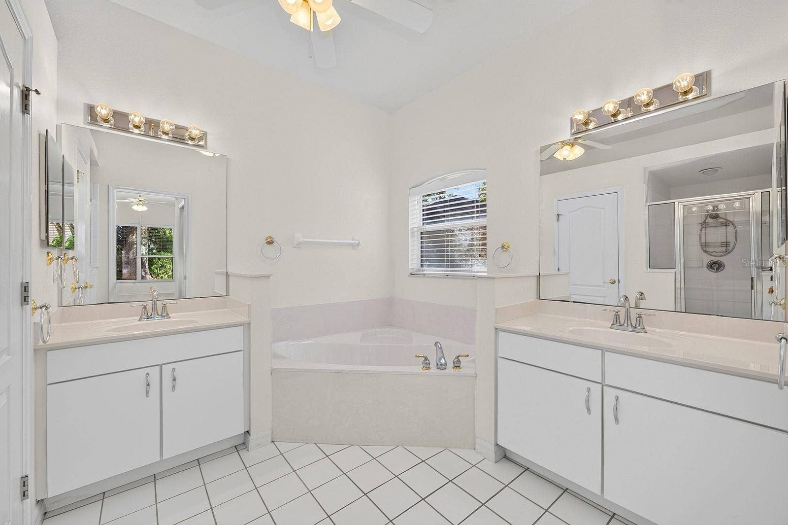 The PRIVATE EN SUITE BATH features dual vanities, a relaxing garden tub, a separate step-in shower with a NEWER LIGHT (2023), and a private water closet.