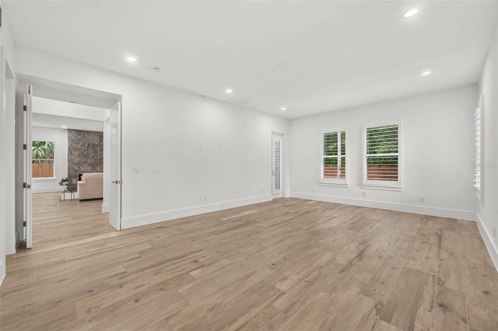 Downstairs Primary Suite with access to the covered rear lanai & backyard