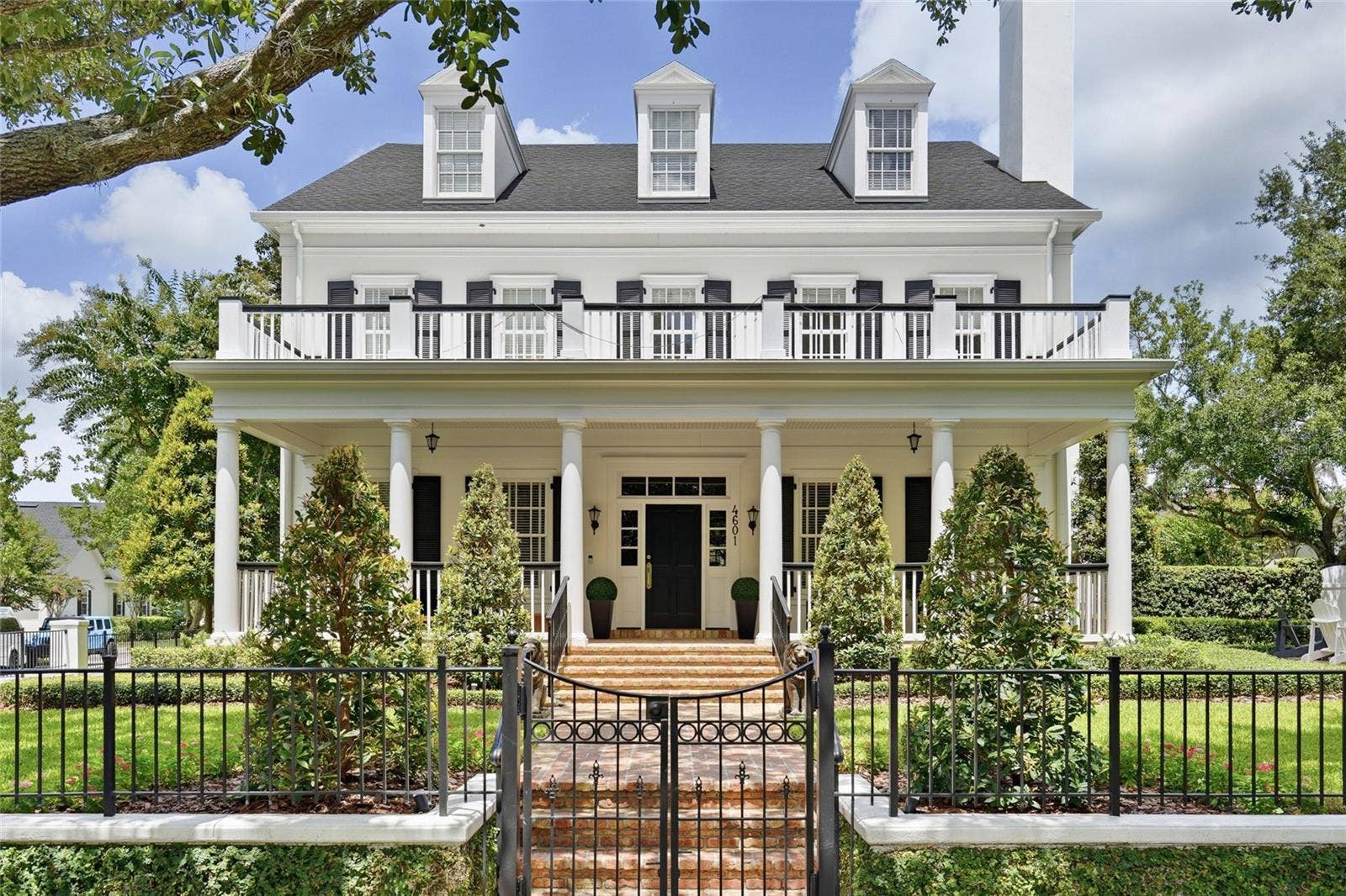 4601 NEW BROAD STREET, Orlando, FL 32814 A striking front elevation showcases the homes symmetrical design, expansive covered porch, upper balcony and beautifully manicured landscaping.