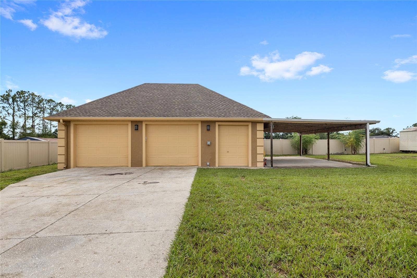12901 PHILLIPS ROAD, Groveland, FL 34736 Detached two car garage with storage room, carport, and RV PLUG