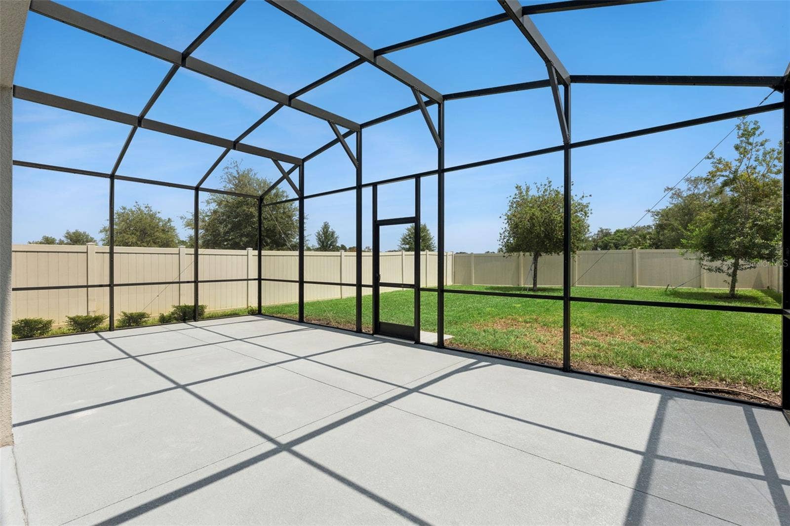 Screened Patio  Another view of the screened patio showcases its open layout and convenient access to the grassy backyard.