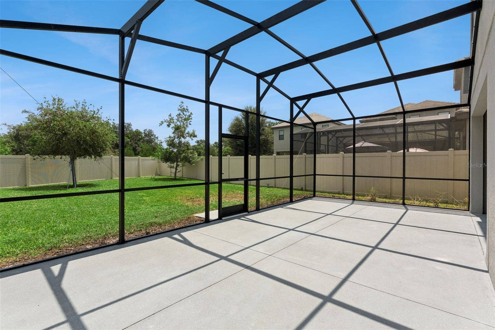 Screened Patio  Expansive screened enclosure extends the home's living space outdoors while overlooking the fenced backyard.