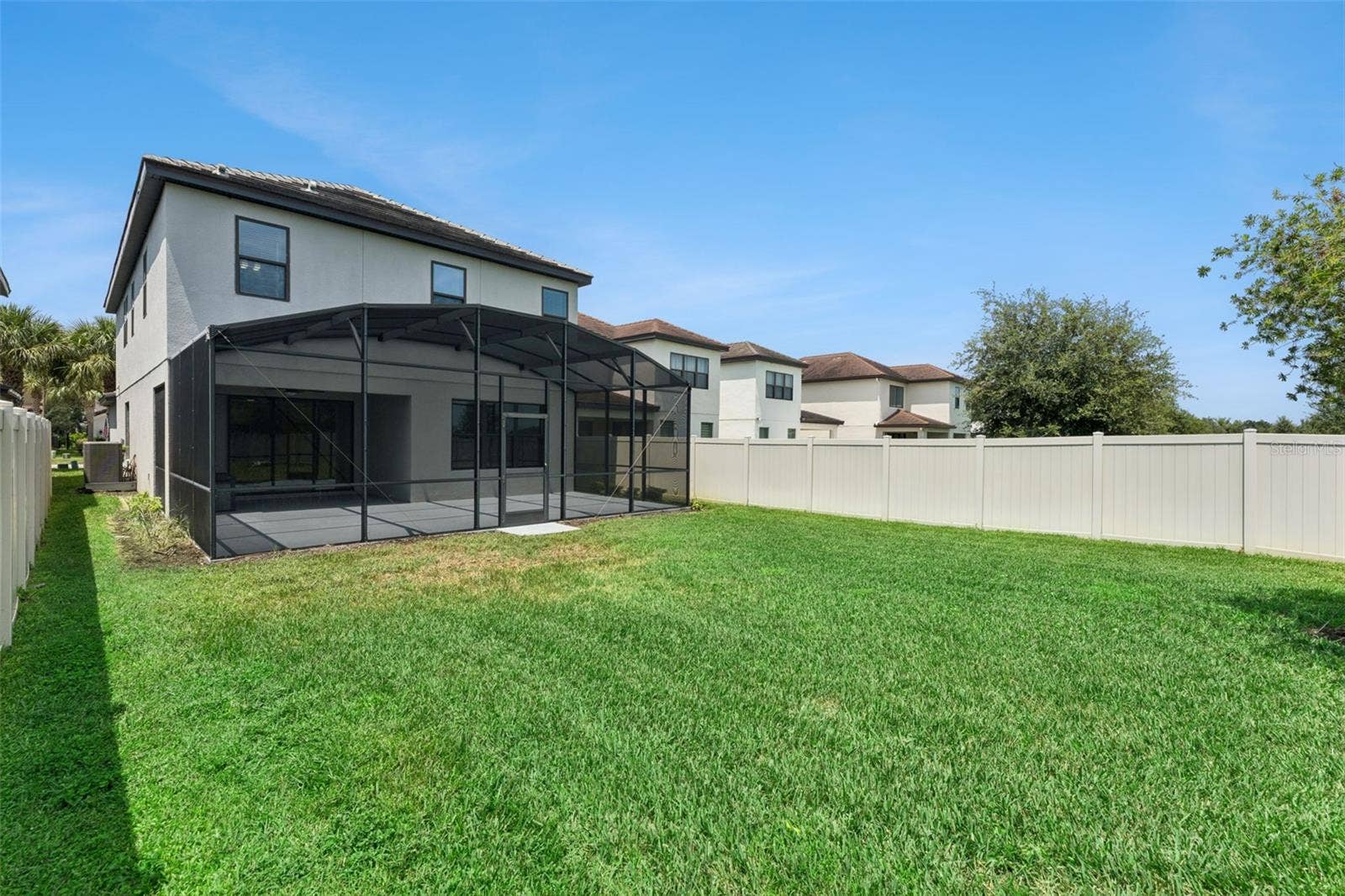 Fenced Backyard  Generously sized fenced backyard provides ample green space alongside the screened outdoor living area.