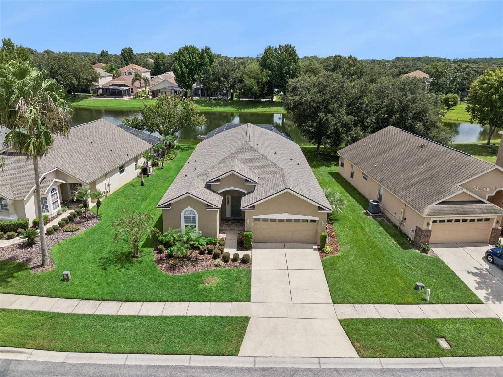 9154 PECKY CYPRESS WAY, Orlando, FL 32836 Front Aerial / Opening Photo Welcome to 9154 Pecky Cypress Way, where an inviting single-story home, manicured landscaping, and a picturesque pond setting create a memorable first impression.