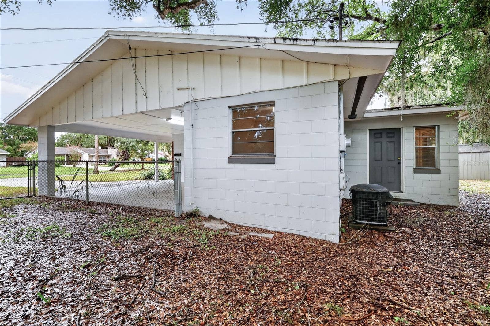 1305 ORANGE AVENUE, Tavares, FL 32778 Exterior Side View of the Home/Covered Carport