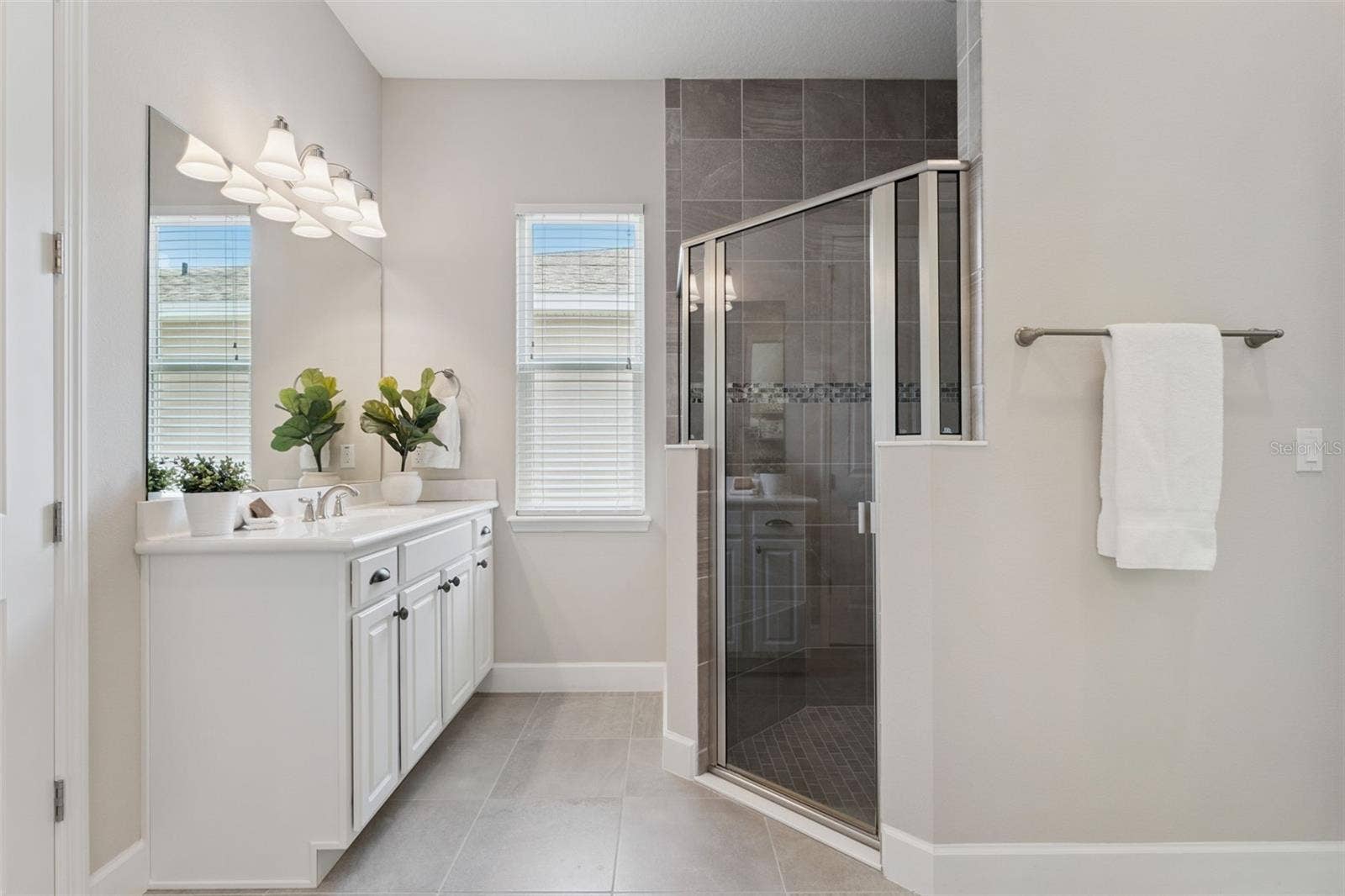 Primary Bathroom glass enclosed walk-in shower w/ a corner bench seat