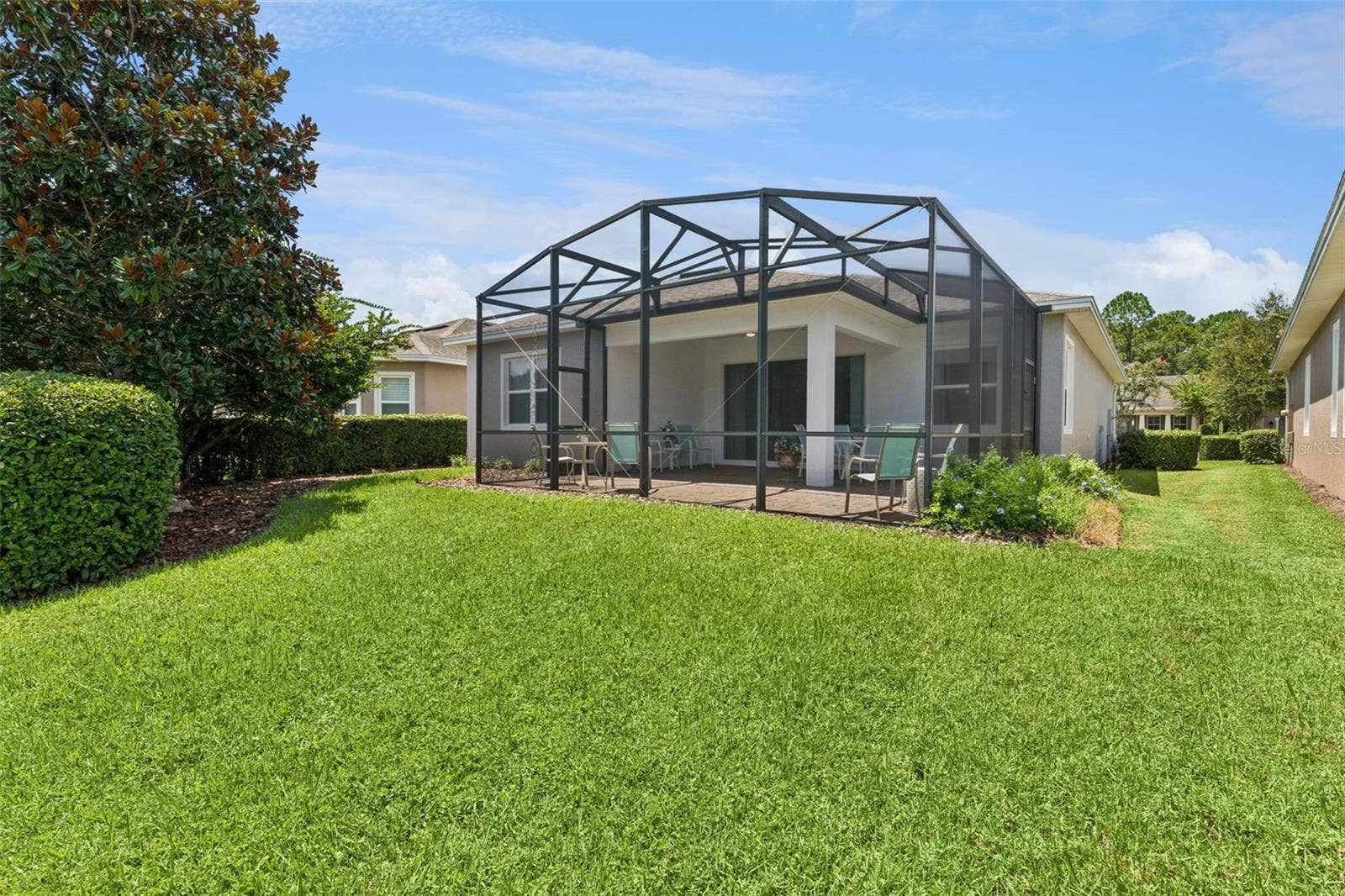 View of the backyard & screen enclosed covered lanai