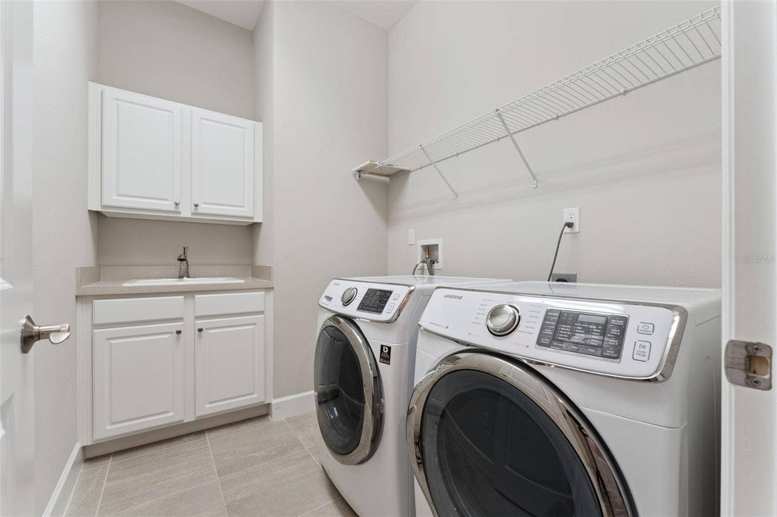 9'6" x 6' Utility Room w/ built-in laundry tub, storage cabinets, washer, electric dryer & a natural gas connection for the future