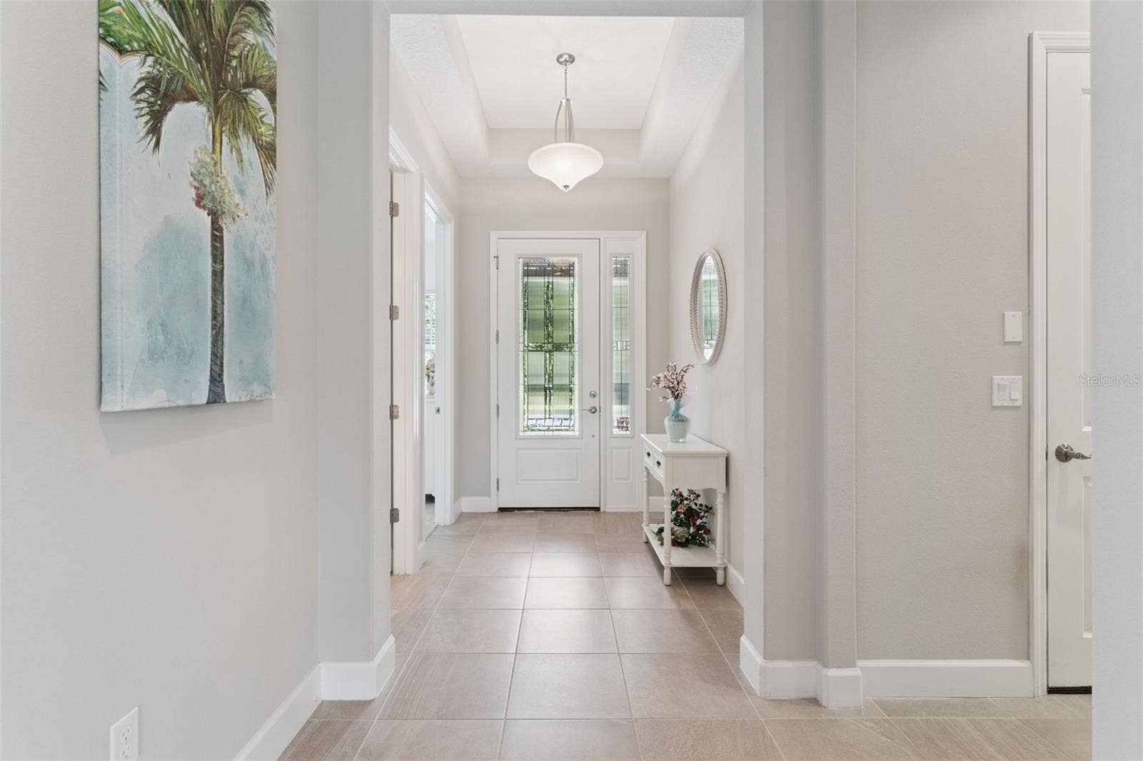 Foyer entryway w/ leaded front glass door, tray ceiling & porcelain tile floors