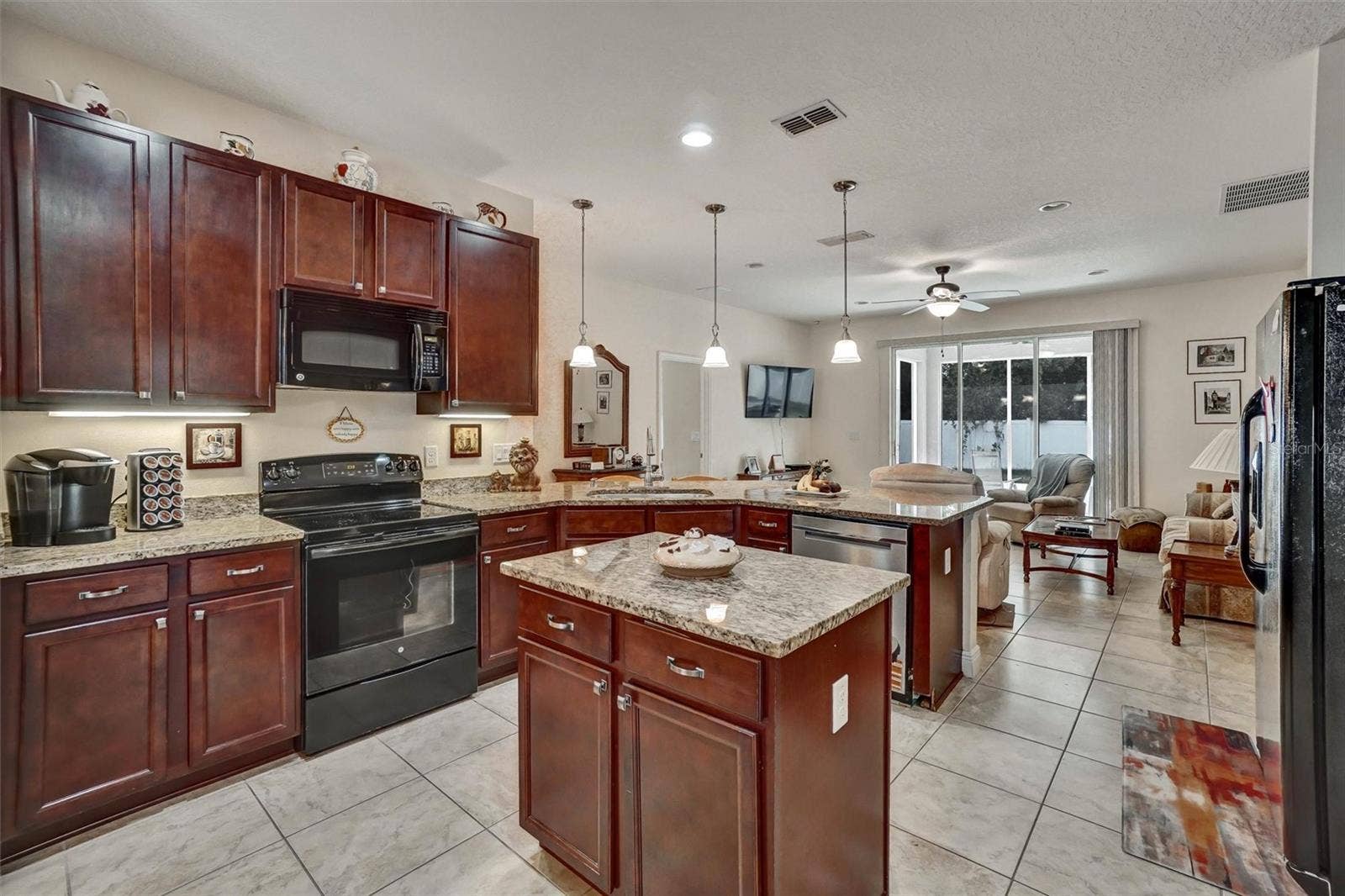Kitchen IslandSpacious kitchen featuring granite countertops, wood cabinetry, and a center island.