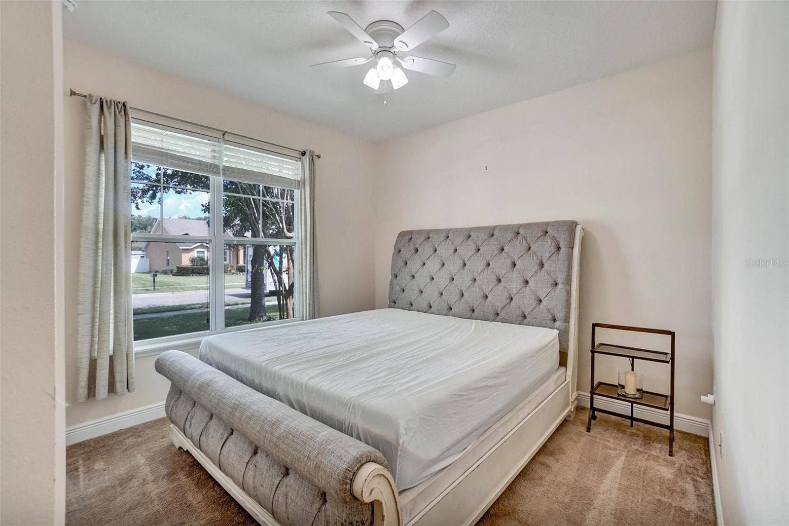 Second BedroomBright bedroom with a ceiling fan, carpeted flooring, and a large window